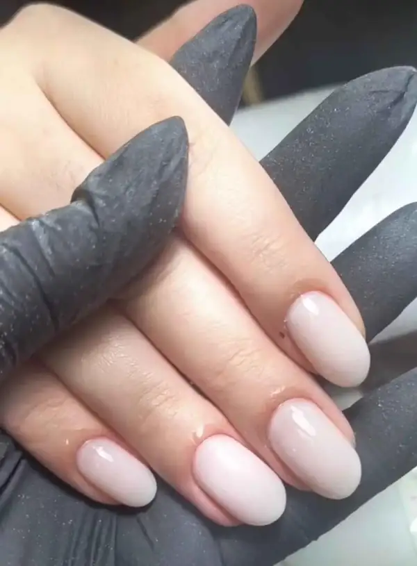 Alongamento de unhas em tom nude sendo finalizado