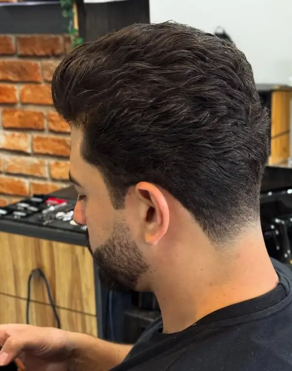 Barbeiro finalizando o corte de um cliente
